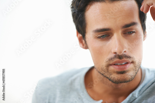 Man, thinking and depressed with mental health or serious or sad and isolated on white background. Closeup, male person face contemplating and worried or in thought and feeling stress alone in studio