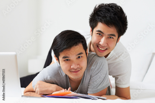 Portrait, lgbt and love with an asian couple learning together in their home while bonding over education. Study, happy or smile with a gay man and partner in a house, studying as university students