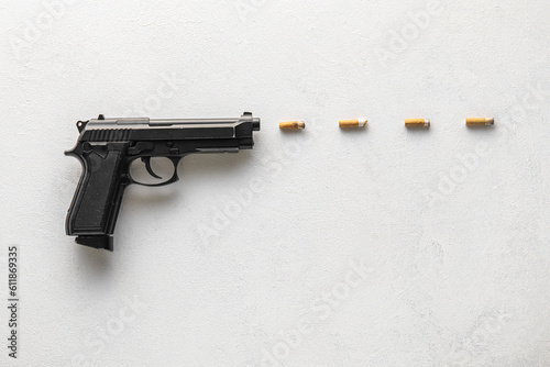 Composition with gun and cigarette filters on light background. Stop smoking concept