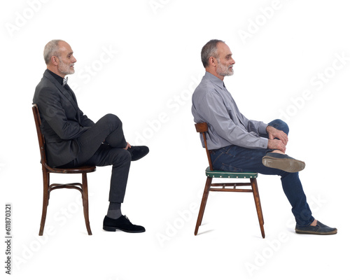 side view of the same man sitting and dressed in a suit and casual clothing on white background