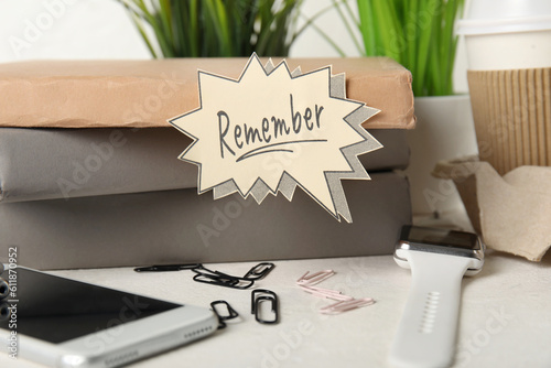 Books with reminder, devices and cup of coffee on white table