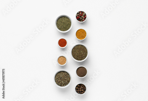 Composition with bowls of different aromatic spices on light background