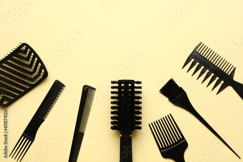 Hairdresser s brushes on yellow background