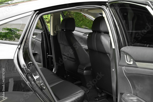 The rear passenger seat is wide and clean. Leather interior  side view  solar sunroof  buttons  Nappa leather  beige black
