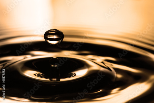 Falling coffee drop on the water surface with waves and splash. macro view, shallow depth of field.