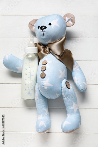 Teddy bear with bottle of m...
