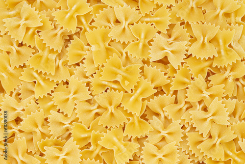 Dry uncooked farfalle pasta as a background. Flat lay.