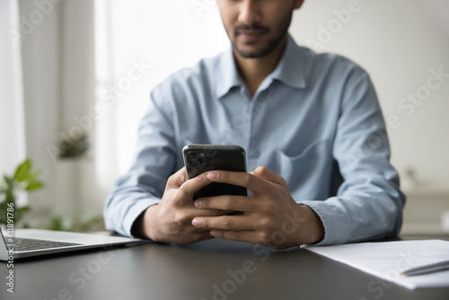 Close up of cellphone in businessman hands. Young business professional man using internet technology, digital gadgets for job communication, typing on mobile phone. Cropped shot on object