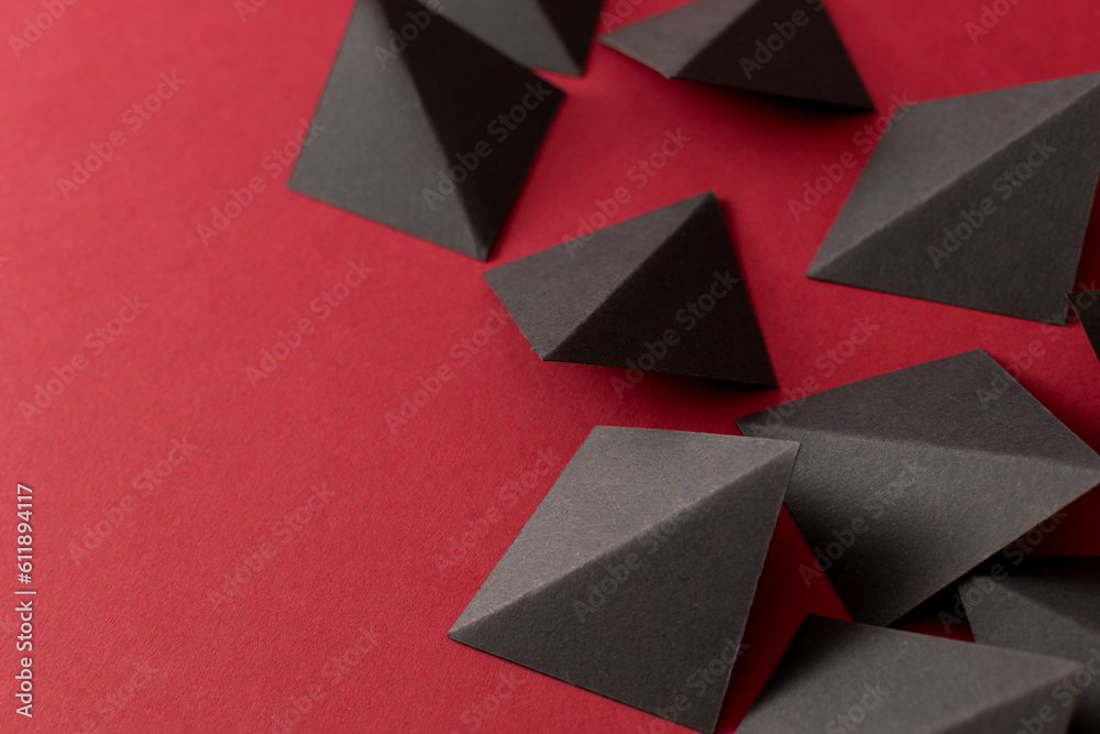 Fototapeta premium Black geometric shapes on red background, copy space