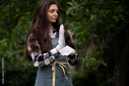 young woman put on and wear white gloves in the garden to protect hands
