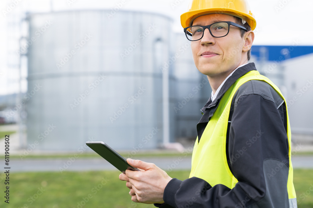 Engineer with digital tablet on a background of gas tanks. Engineer with digital tablet on a background of gas tanks.