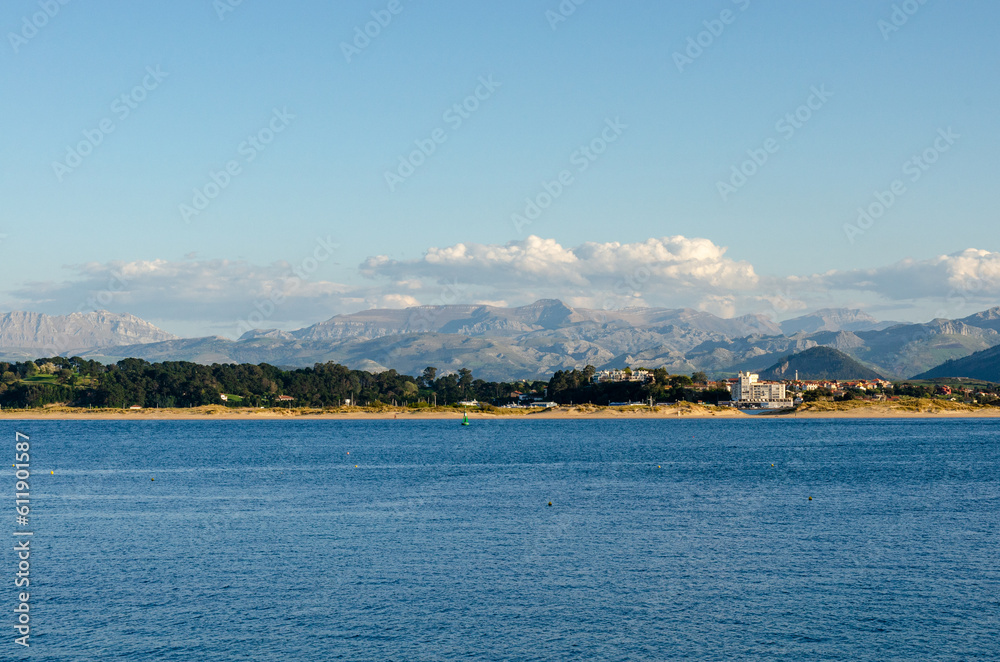 Sunny spanish coastline with calm sea. Dramatic mountains in the background.