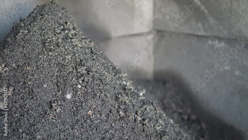 Coal slag grains onto pile in industrial plant storage slow motion. Recyclable fossil fuel leftovers collected in heating station warehouse closeup