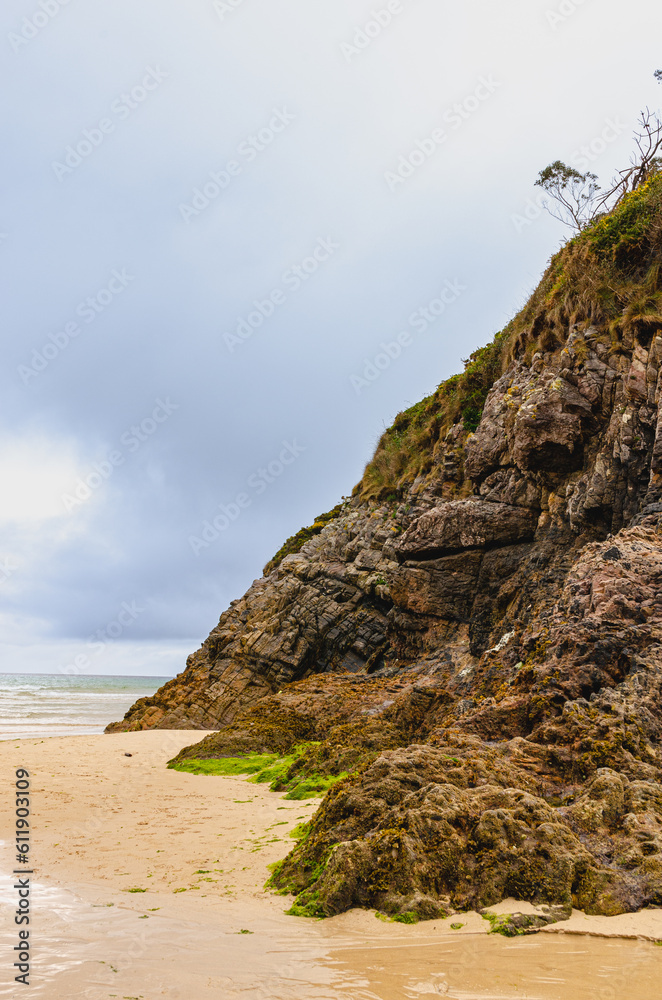 Sandy beach with a majestic rock side. 