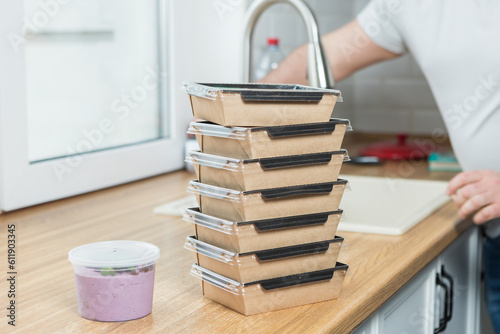 food containers are stacked on the kitchen counter.