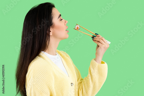 Young woman eating sushi ro...