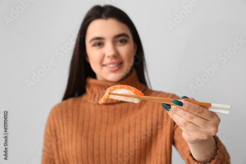Young woman with sushi on l...