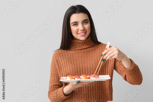 Young woman with sushi on l...