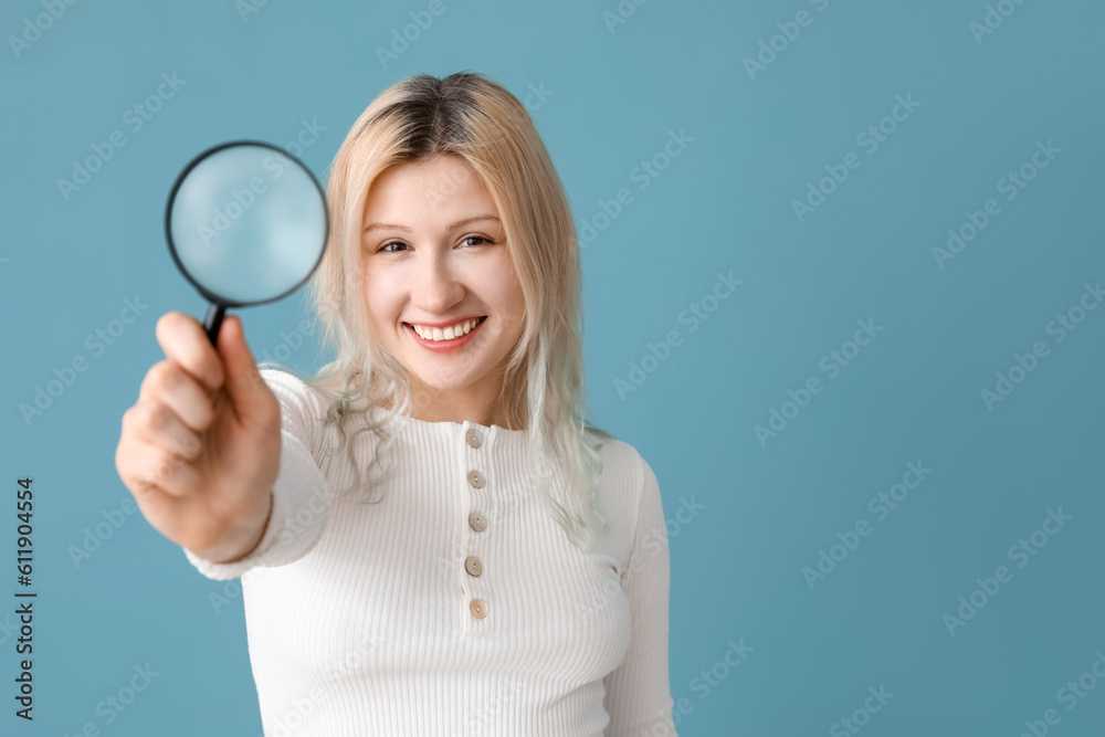 Young woman with magnifier on blue background, closeup Young woman with magnifier on blue background, closeup