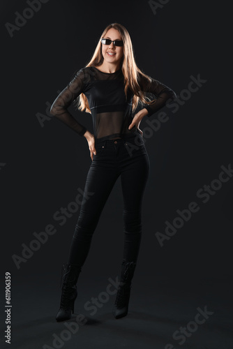 Young woman in sunglasses on dark background