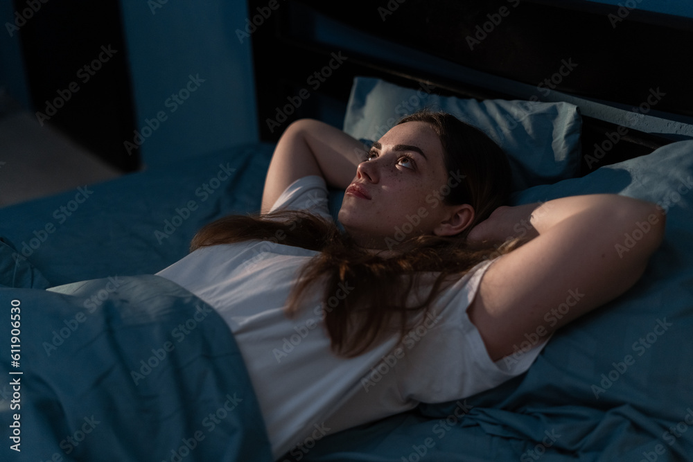Sleep disorder, insomnia. Young woman lying on the bed awake at late night. Can not sleep Sleep disorder, insomnia. Young woman lying on the bed awake at late night. Can not sleep