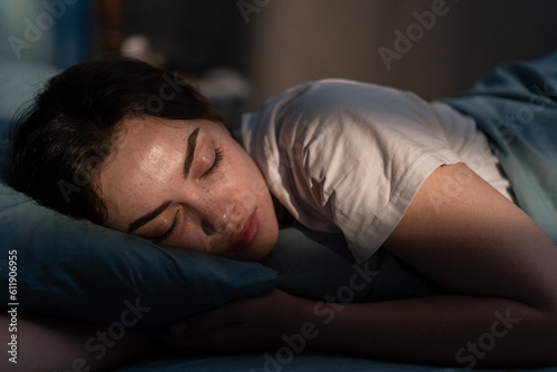Εκτύπωση καμβά Portrait of beautiful young woman sleeping cozily on a bed in her bedroom at night