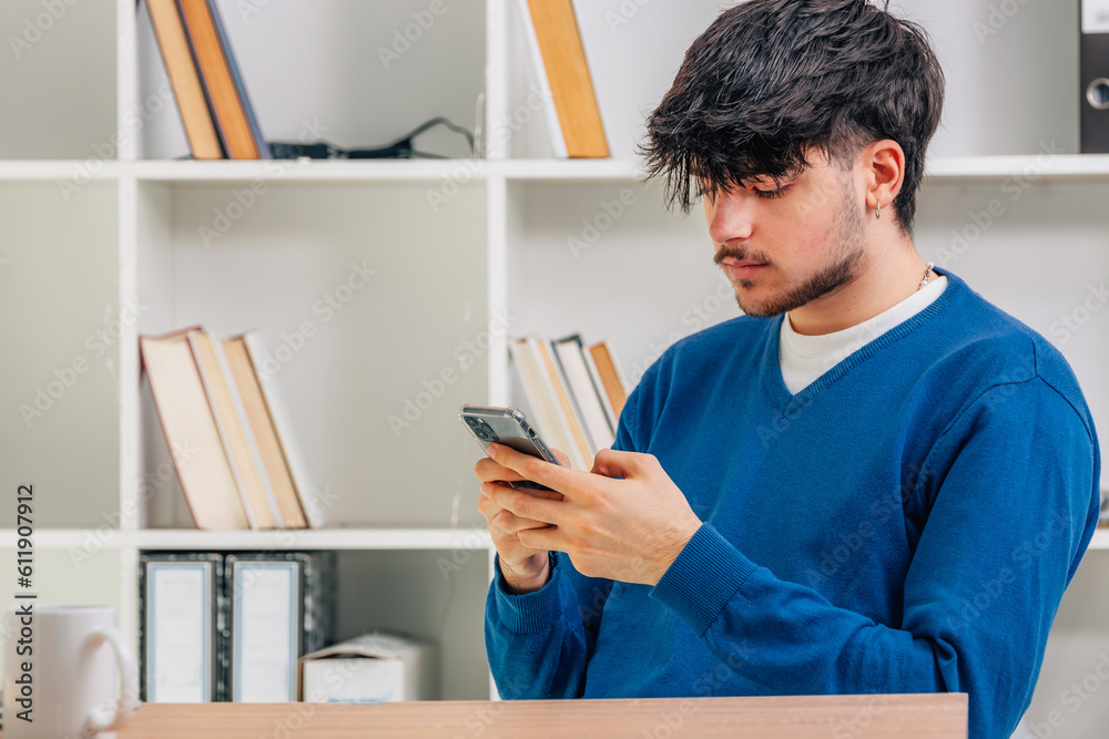 young male student with mobile phone or smartphone young male student with mobile phone or smartphone