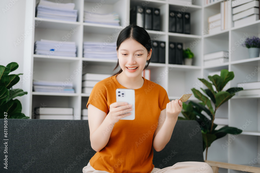 Woman using smart phone for mobile payments online shopping,omni channel,sitting on table in morning light Woman using smart phone for mobile payments online shopping,omni channel,sitting on table in morning light