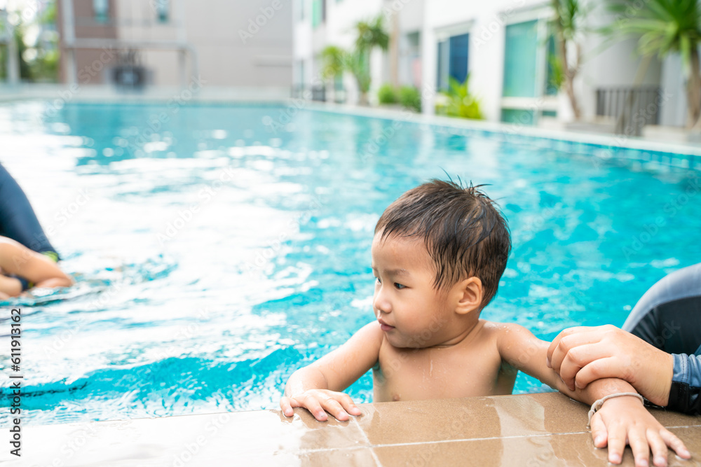 Adorable little boy swim with mom in condominium swimming pool