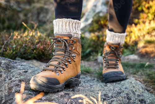Hiking boot and alpaca sock. Legs with ankle boots on mountain trekking trail