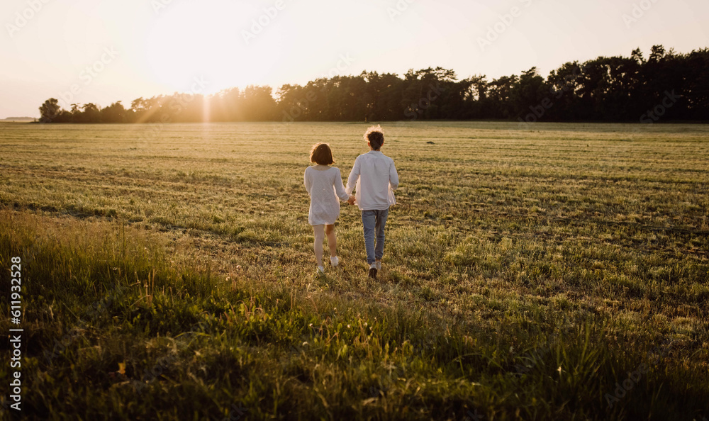 couple in love in a field at sunset on a date in summer. Wedding engagement of a young couple.