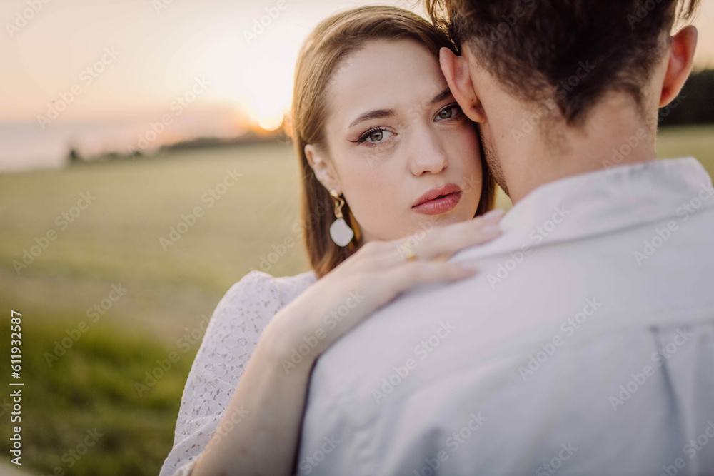 couple in love in a field at sunset on a date in summer. Wedding engagement of a young couple. couple in love in a field at sunset on a date in summer. Wedding engagement of a young couple.