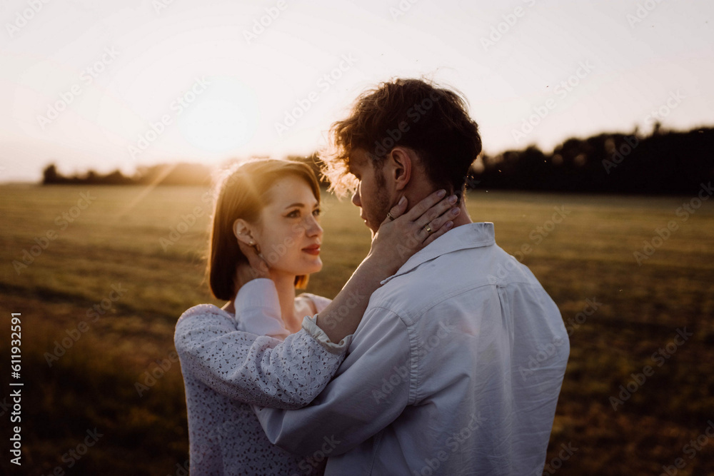 couple in love in a field at sunset on a date in summer. Wedding engagement of a young couple. couple in love in a field at sunset on a date in summer. Wedding engagement of a young couple.