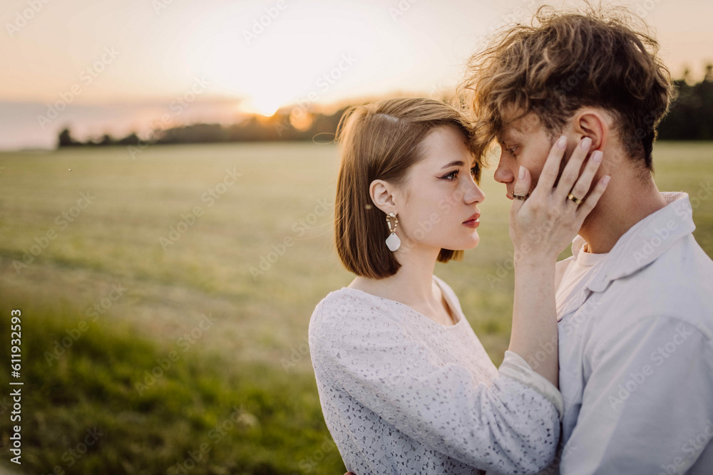couple in love in a field at sunset on a date in summer. Wedding engagement of a young couple. couple in love in a field at sunset on a date in summer. Wedding engagement of a young couple.
