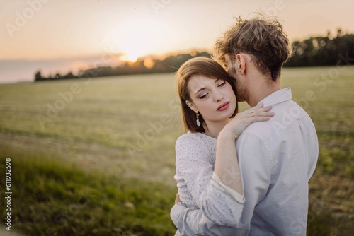 couple in love in a field at sunset on a date in summer. Wedding engagement of a young couple.