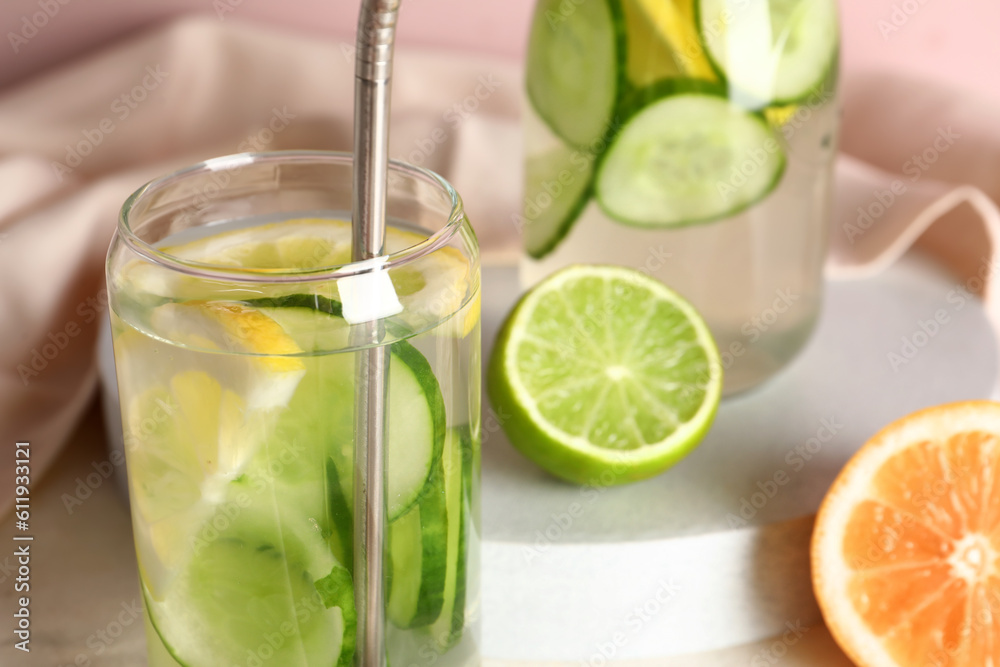 Glass and bottle of infused water with cucumber slices, closeup Glass and bottle of infused water with cucumber slices, closeup