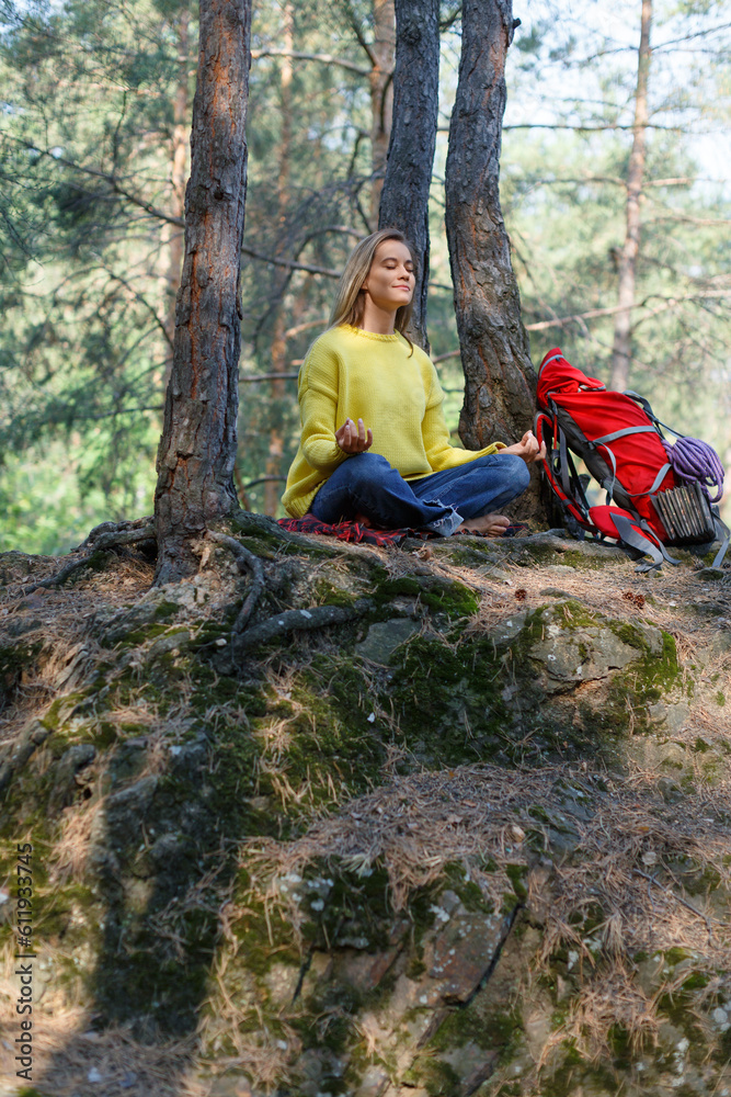 Breath with the forest and free your mind with meditation. Young woman in a morning pine forest. Solitude with your thoughts and nature. Nature as a path to mental health.