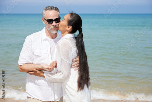 couple looking each other and kissing on the beach