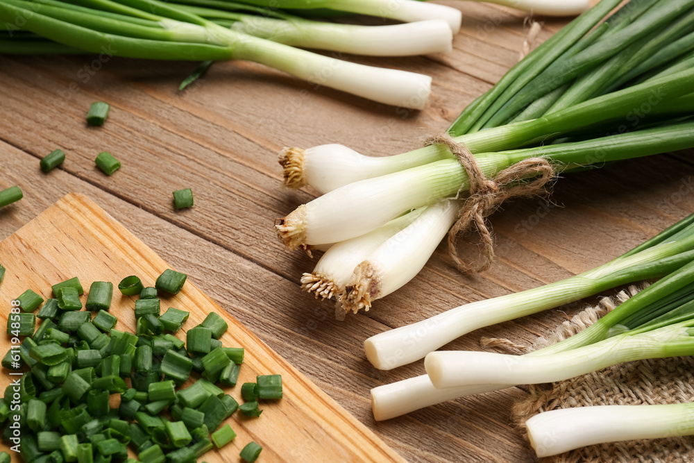 Board with slices of fresh green onion on wooden background Board with slices of fresh green onion on wooden background