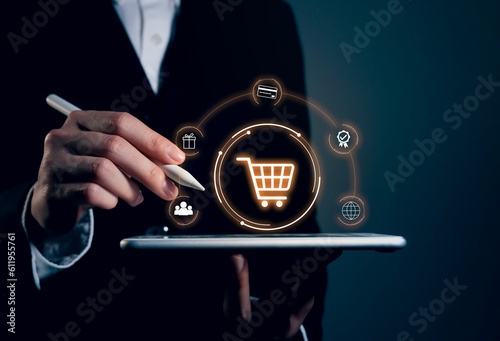Businessman holding smartphone and showing shopping cart.