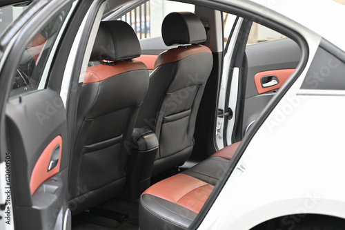 inside the back seat The passenger seat is wide and clean. Leather interior design, car passenger and driver seats, clean, angle view side, sunroof solar, buttons, dashboard, nappa leather, beige.