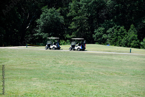 Golf carts at course greens background. © itsallgood