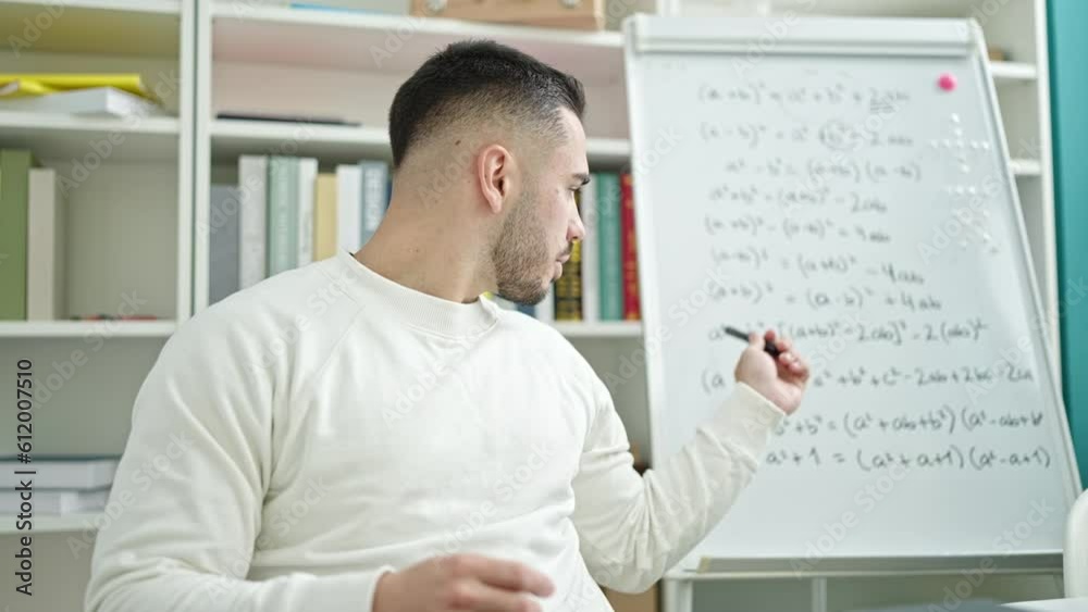 Young hispanic man teacher teaching maths lesson at library university Young hispanic man teacher teaching maths lesson at library university