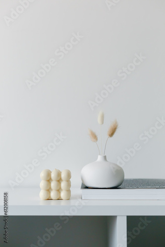 Dried hare s tail grass.Aesthetic cozy home decoration. Scandinavian minimal interior style. Hygge scene with candles. Creative composition of living room interior with copy space. Stylish round vase.