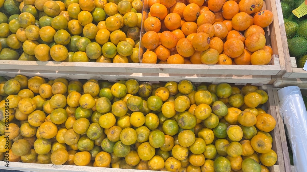 Green oranges and orange tangerines in the market Green oranges and orange tangerines in the market