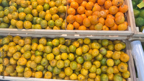 Green oranges and orange tangerines in the market