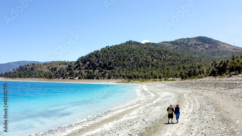 Couple hold hands walking Lake Salda romantic Turkish beach 