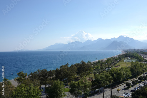 Landscape with logn beach and park  cloudless sky  sea and mountains at far in Antalya resort area