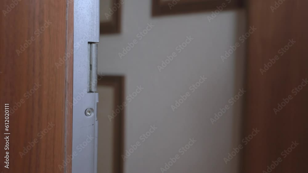 The camera focuses on a door handle as a person enters, carrying a shopping bag. A close-up of the bag, full of groceries. A simple yet effective depiction of a routine shopping trip The camera focuses on a door handle as a person enters, carrying a shopping bag. A close-up of the bag, full of groceries. A simple yet effective depiction of a routine shopping trip