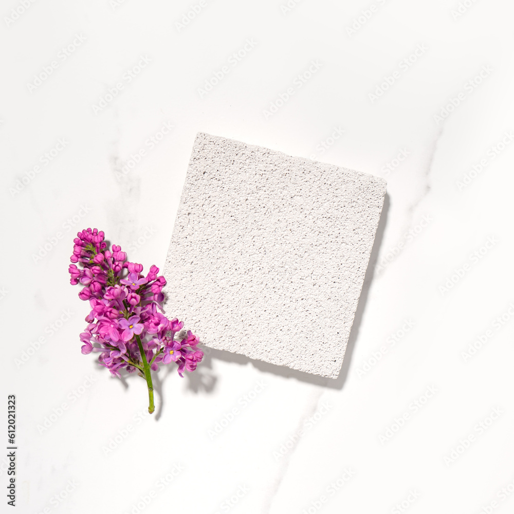 Cosmetics skin care product presentation flat lay scene and display made with pumice stone podium and lilac flowers. Studio photography. Square composition. Cosmetics skin care product presentation flat lay scene and display made with pumice stone podium and lilac flowers. Studio photography. Square composition.